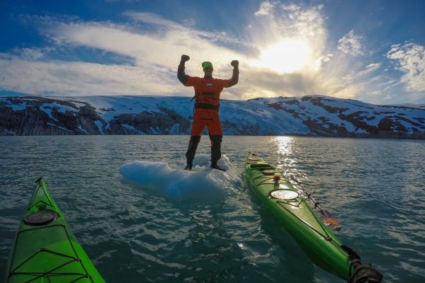 guided tours at svartisen glacier with kayaks, stand on top of a floating iceberg